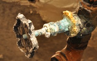 Plumber repairing a corroded pipe in a Nogales basement