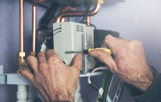 Plumber servicing a tankless water heater in a Nogales home